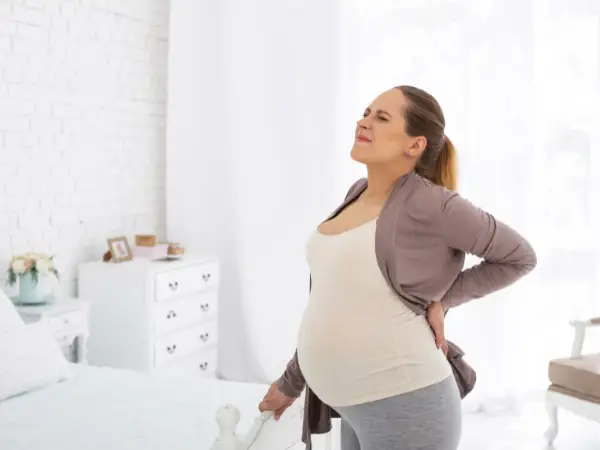 Zwangere lange vrouw heeft last van rug