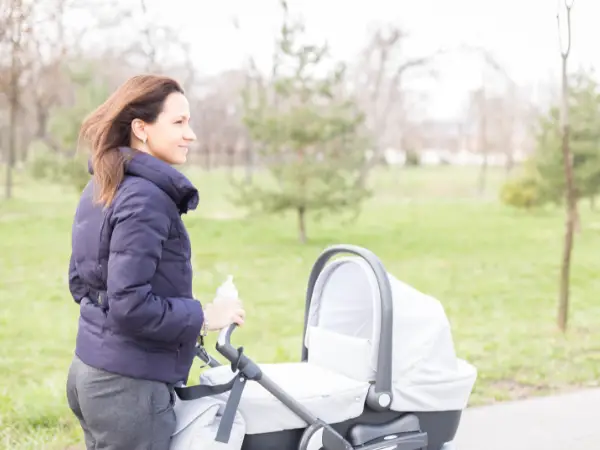 Lange ouder duwt haar kinderwagen voor lange mensen vooruit
