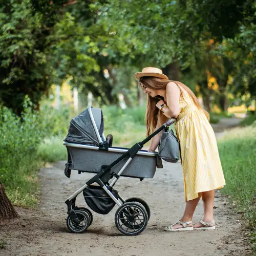 Moeder met kinderwagen in bos